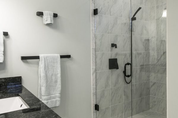 Ultra modern bathroom with glass shower and marble and granite tile and sink.